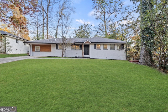 ranch-style home with concrete driveway and a front lawn