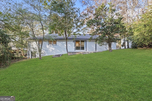 back of property featuring a yard