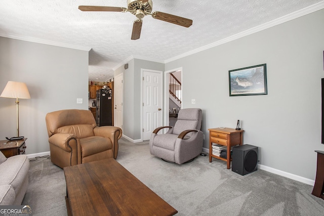 carpeted living area with crown molding, baseboards, stairs, a textured ceiling, and a ceiling fan