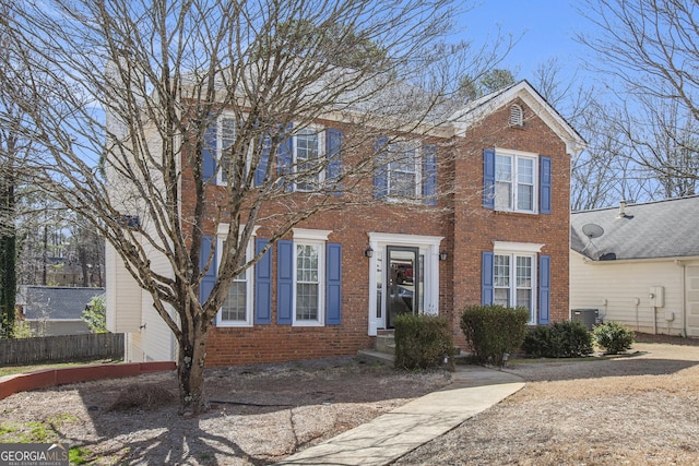 colonial house with brick siding and fence