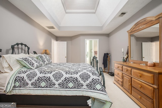 bedroom featuring a raised ceiling, visible vents, and light carpet