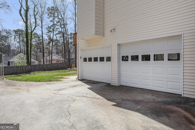 garage featuring fence and driveway