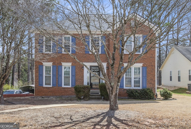 view of front of home with a detached carport, central AC unit, and brick siding