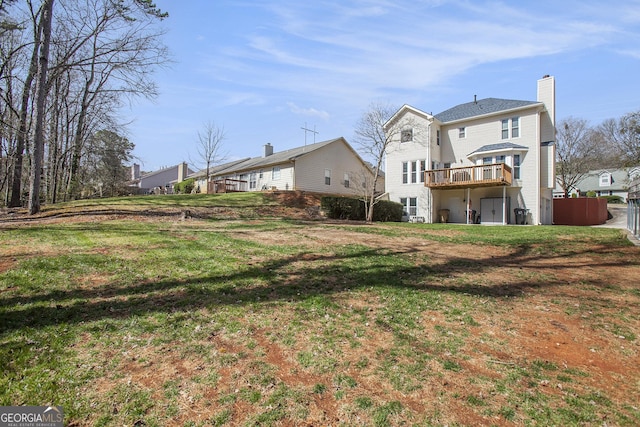 rear view of property with a lawn, a deck, and a chimney