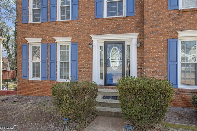 view of exterior entry with brick siding