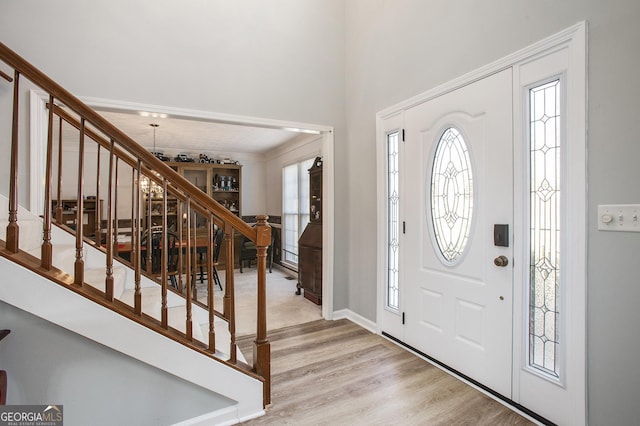 foyer entrance with stairway and light wood-style floors