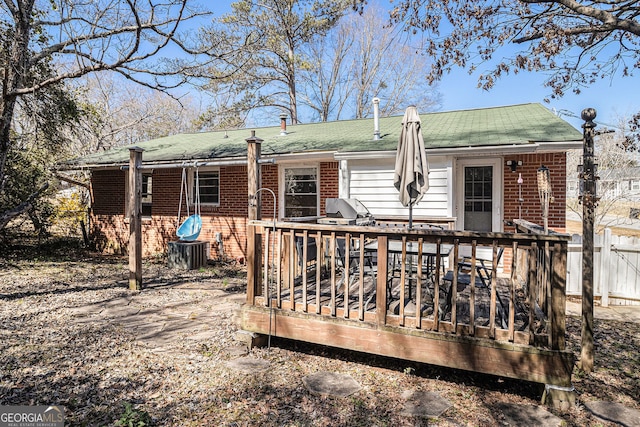 back of property featuring a wooden deck and brick siding