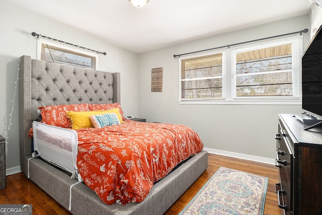 bedroom featuring baseboards, multiple windows, and wood finished floors