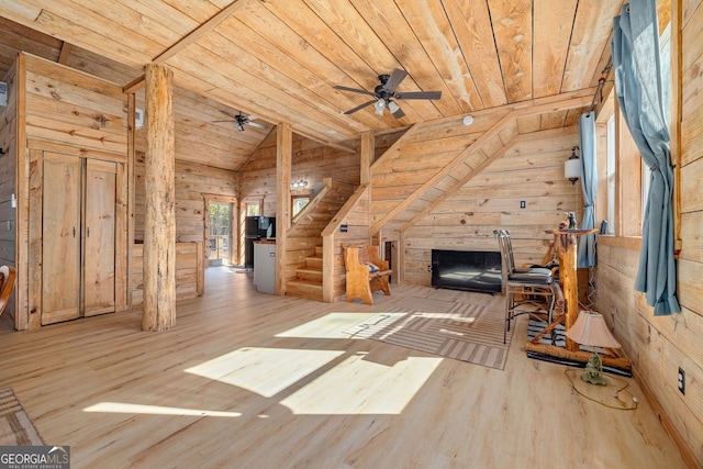 unfurnished living room with wood walls, wooden ceiling, lofted ceiling, and wood finished floors