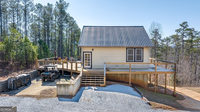 view of front facade featuring metal roof and a wooden deck