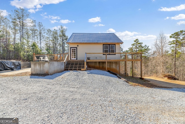 rear view of house with a deck and metal roof