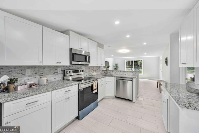 192 Hoke St, Maysville, GA 30558 - kitchen featuring white cabinets, stainless steel appliances, decorative backsplash, and a healthy amount of sunlight