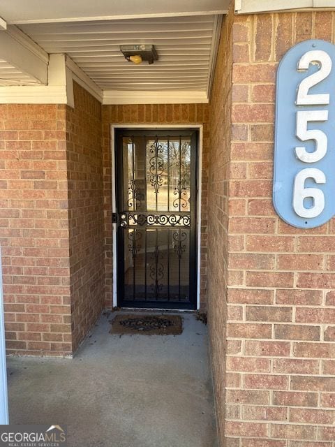 entrance to property featuring brick siding