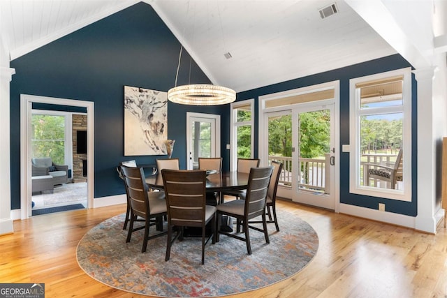 dining area with visible vents, high vaulted ceiling, baseboards, and wood finished floors