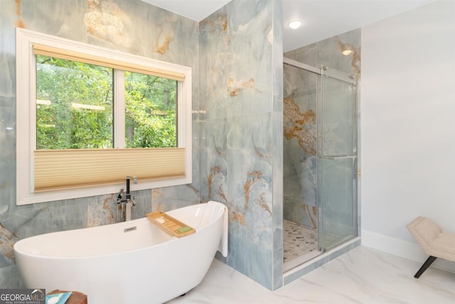 bathroom with tile walls, a soaking tub, marble finish floor, and a stall shower