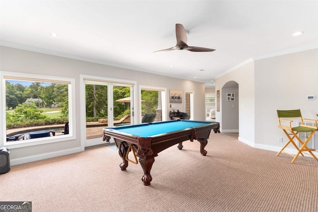 recreation room with arched walkways, light colored carpet, baseboards, and ornamental molding