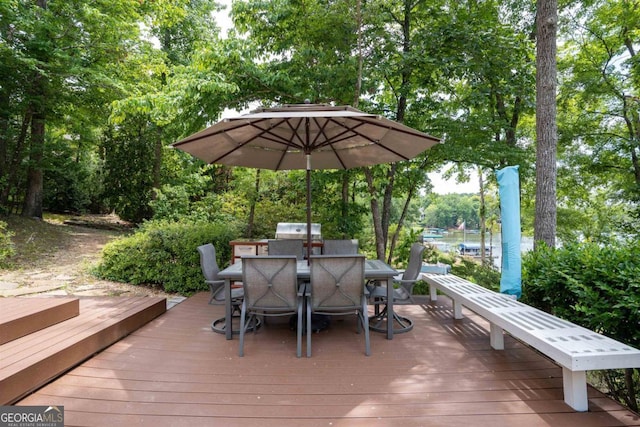 deck with outdoor dining space and grilling area