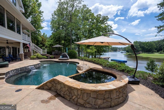 outdoor pool with a patio, stairs, and a water view