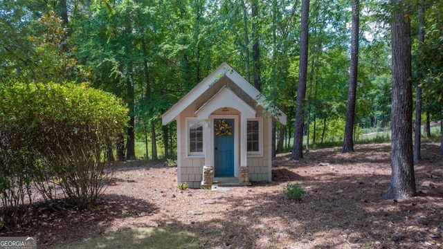 view of outbuilding with a view of trees and an outdoor structure