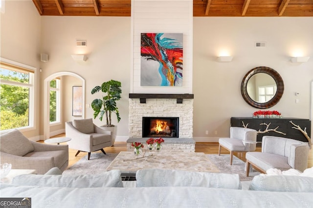 living area featuring beamed ceiling, wood finished floors, visible vents, and wooden ceiling