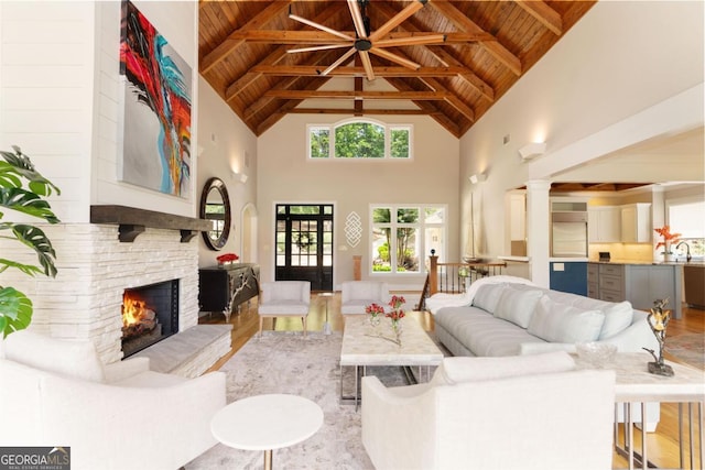 living room featuring a fireplace, beam ceiling, and wood ceiling