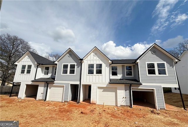 view of front of house with board and batten siding, a garage, and roof with shingles