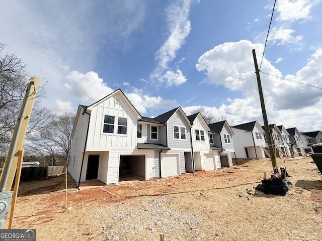 view of front of property with an attached garage, board and batten siding, and a residential view