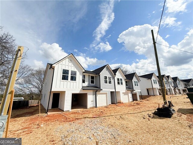view of front of home with a residential view, board and batten siding, and an attached garage