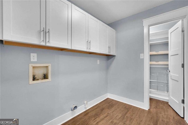 clothes washing area featuring cabinet space, baseboards, hookup for an electric dryer, hookup for a washing machine, and dark wood-style flooring