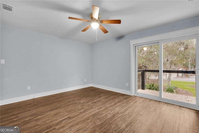 empty room with visible vents, ceiling fan, baseboards, and wood finished floors