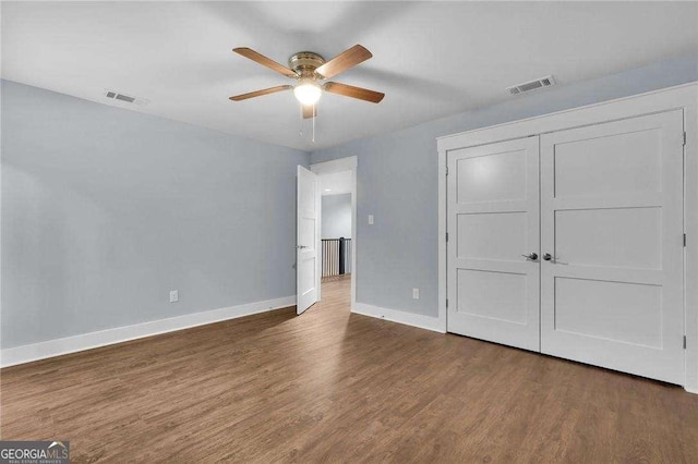 unfurnished bedroom with visible vents, baseboards, and wood finished floors