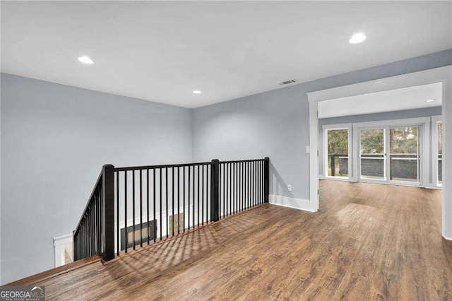 spare room with recessed lighting, visible vents, baseboards, and wood finished floors