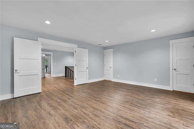 unfurnished living room with recessed lighting, baseboards, and wood finished floors