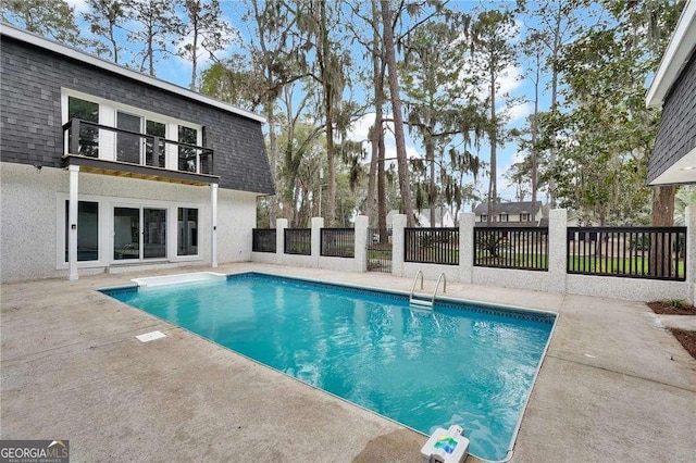 view of swimming pool featuring a patio area, a fenced in pool, and fence