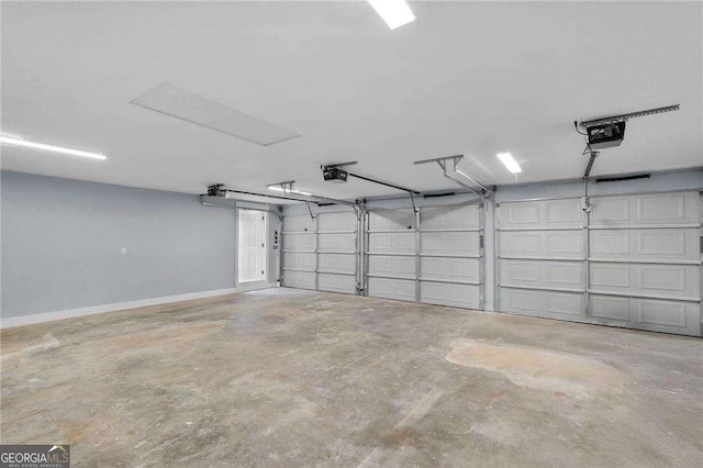 garage with a garage door opener and baseboards