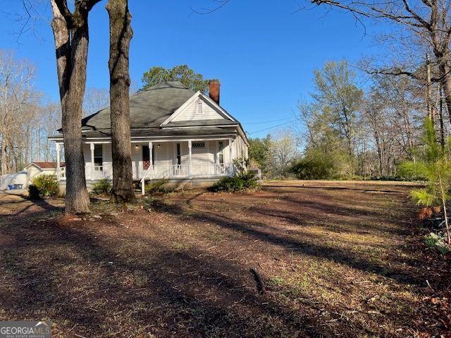 view of front of home with covered porch and a chimney