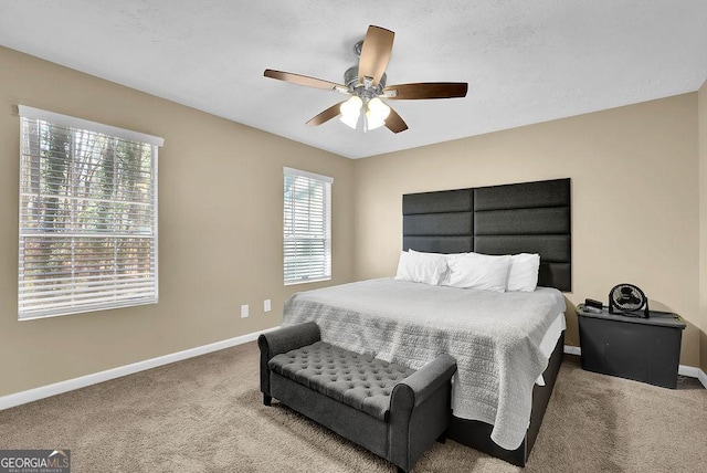 bedroom with a ceiling fan, baseboards, and carpet floors