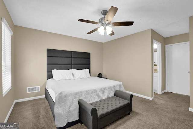 carpeted bedroom featuring visible vents, baseboards, and a ceiling fan