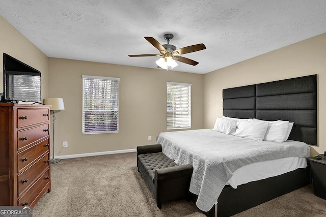 bedroom featuring ceiling fan, carpet, baseboards, and a textured ceiling