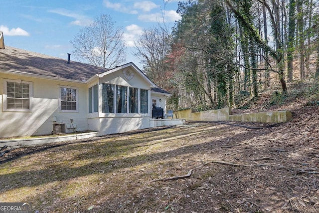 exterior space with cooling unit, roof with shingles, and stucco siding