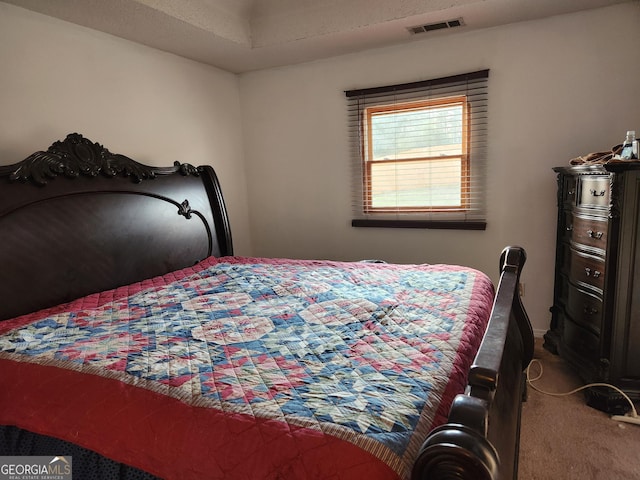 bedroom with visible vents and carpet flooring