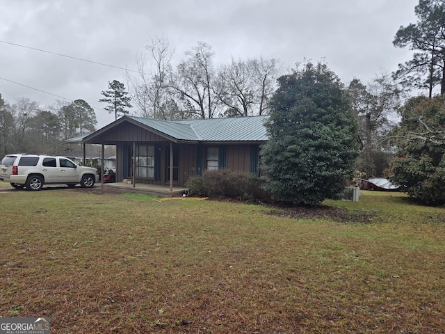 view of front facade featuring a front yard and metal roof