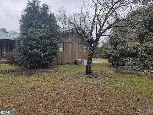 view of side of property with a yard and metal roof