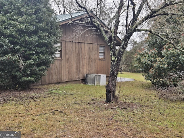 view of home's exterior with a lawn and central AC unit