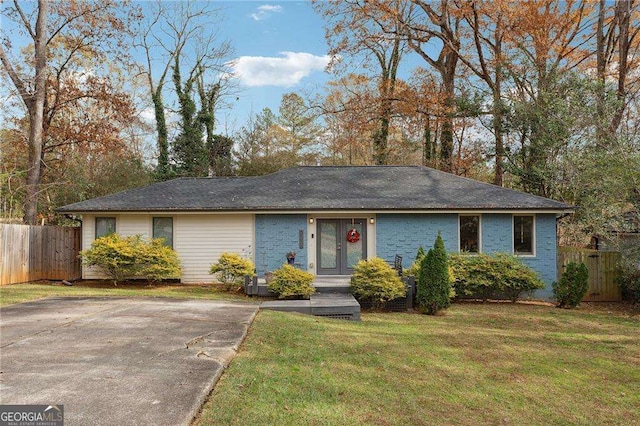 ranch-style home featuring brick siding, a front yard, and fence