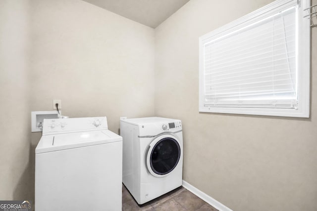 washroom featuring laundry area, baseboards, and washer and clothes dryer