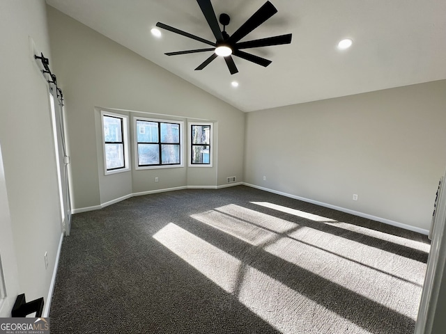 empty room with visible vents, baseboards, dark carpet, a barn door, and a ceiling fan