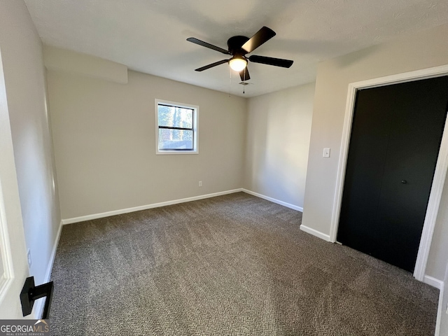 unfurnished bedroom featuring a ceiling fan, baseboards, and dark colored carpet