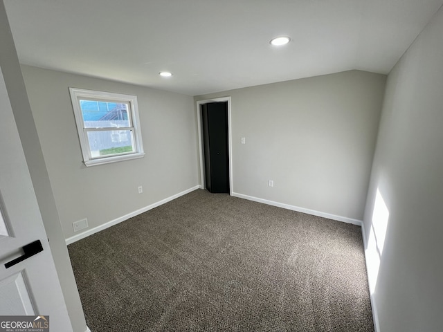 unfurnished room featuring lofted ceiling, recessed lighting, baseboards, and dark colored carpet