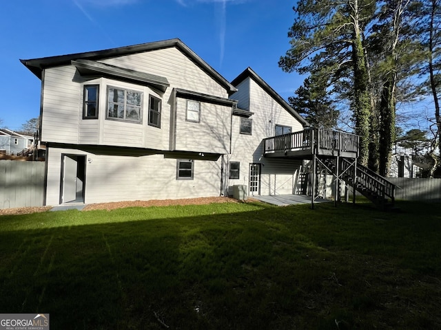 rear view of house with stairway, a deck, a yard, and fence